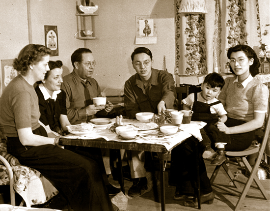 Bill_Hosokawa_Family_1943 In his barracks in Heart Mountain, Bill Hosokawa and his wife Alice visit with the members of the WRA appointed personnel on Jan. 9, 1943. (TomParker/The Bancroft Library UC Berkeley)