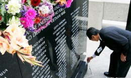Vietnam veteran Dennis Maruki places a flower beside the name of Douglas Harvard Yuki, who was killed in action on Sept. 28, 1970 in South Vietnam. (MARIO G. REYES/Rafu Shimpo)