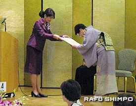 2 同会名誉会長の伊原総領事夫人から感謝状を授与される生田さん(右)